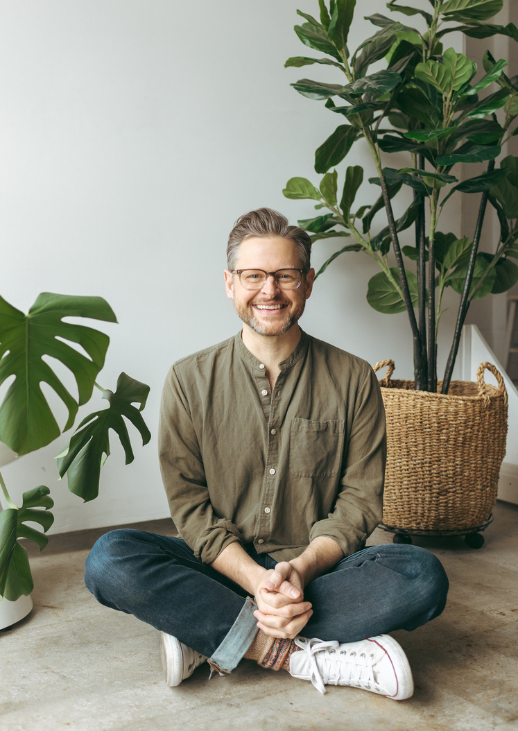 Jay Karr, trauma-informed psychotherapist, seated in a bright room with plants